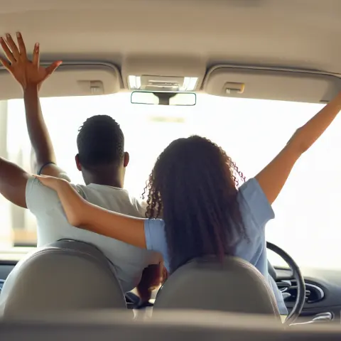 happy couple in car celebrating their new car after getting ca loan through find that finance